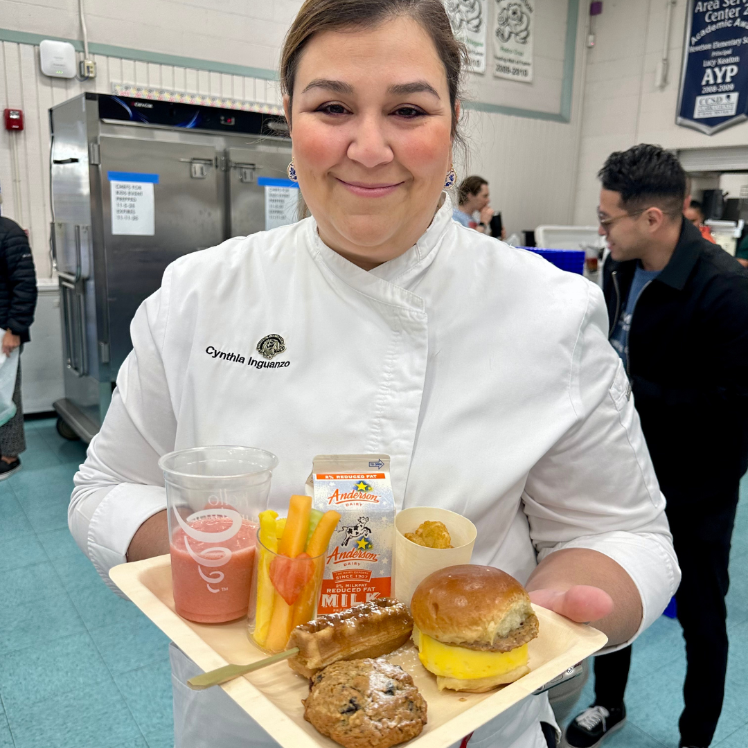 A MGM chef holds a plate of food at Halle Hewetson