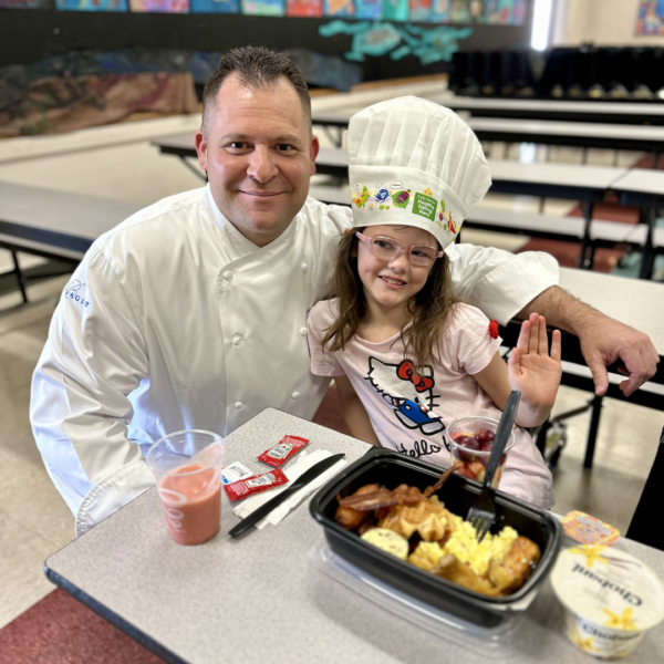 A chef poses with child for a photo at Cahlan ES