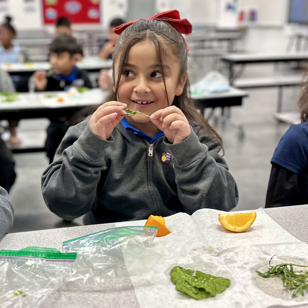 A female student about to eat a piece of arugula