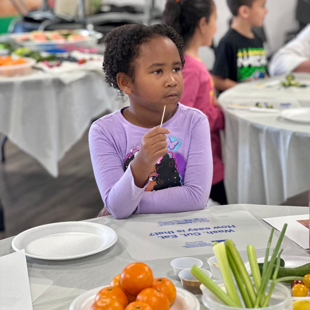 A female students holds a toothpick after tasting produce