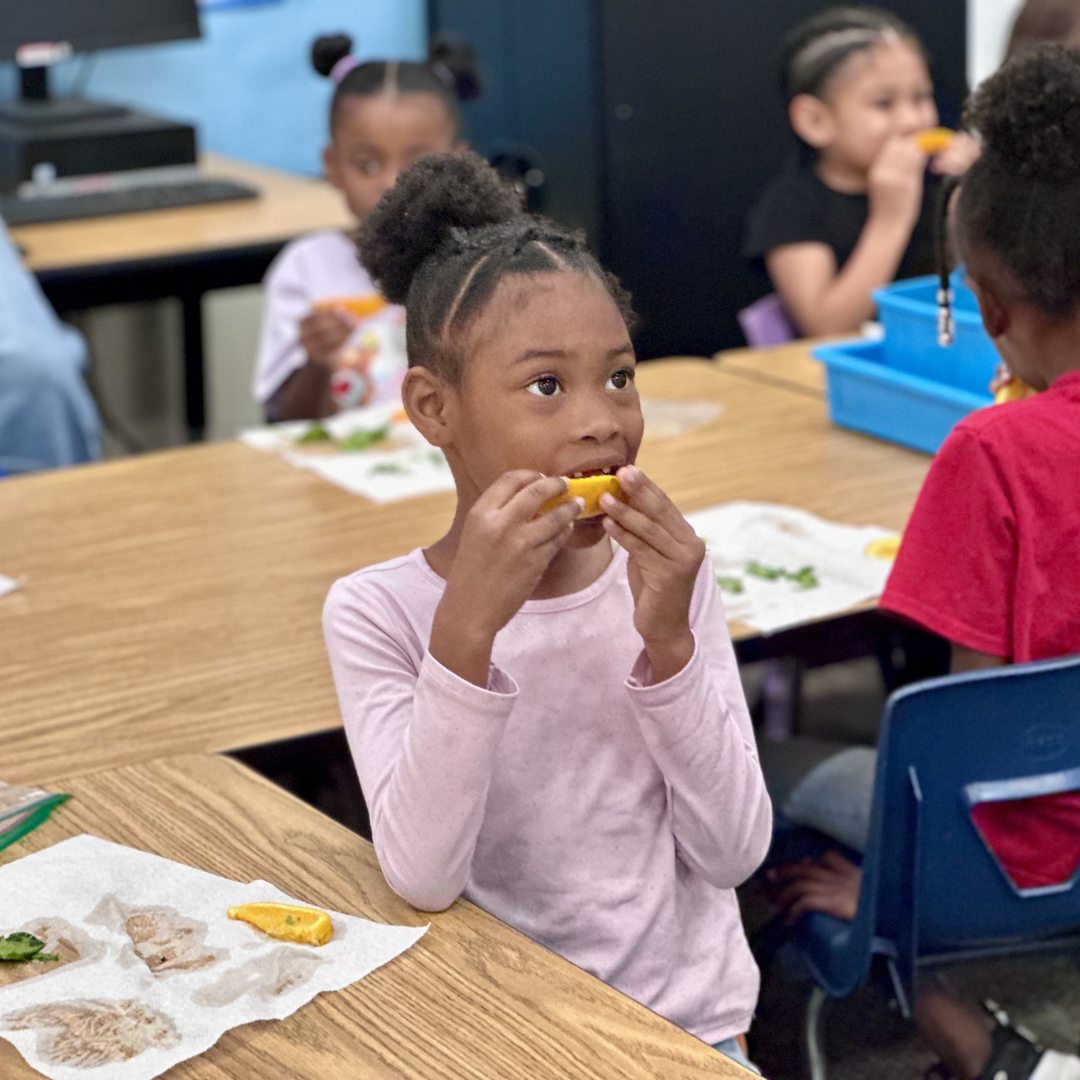 A girl eating an orange