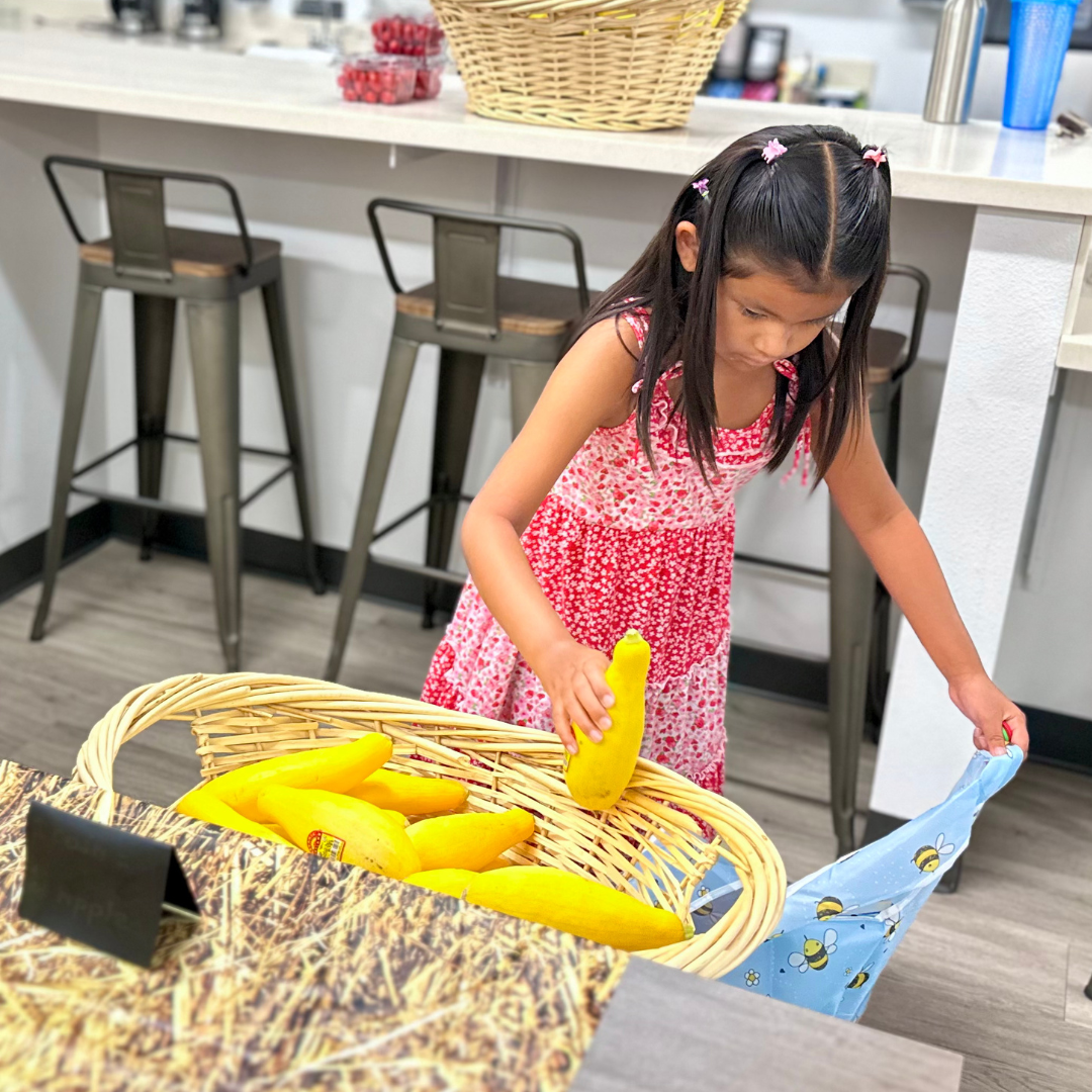 A girl picks out a squash at a farmers market