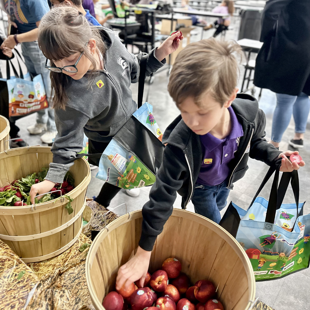 A male and female student shop for produce at the farmers market