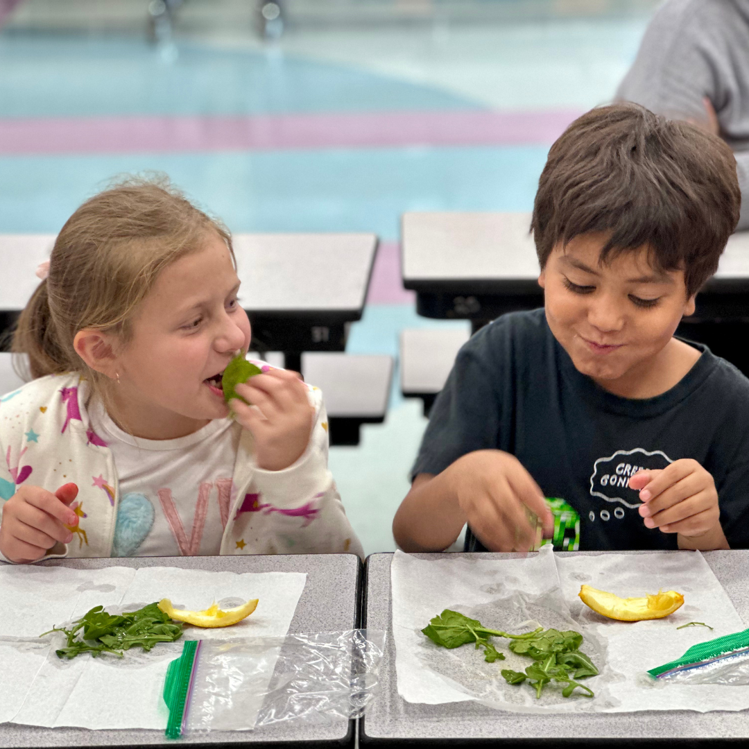 A male and female student try arugula at Ries ES