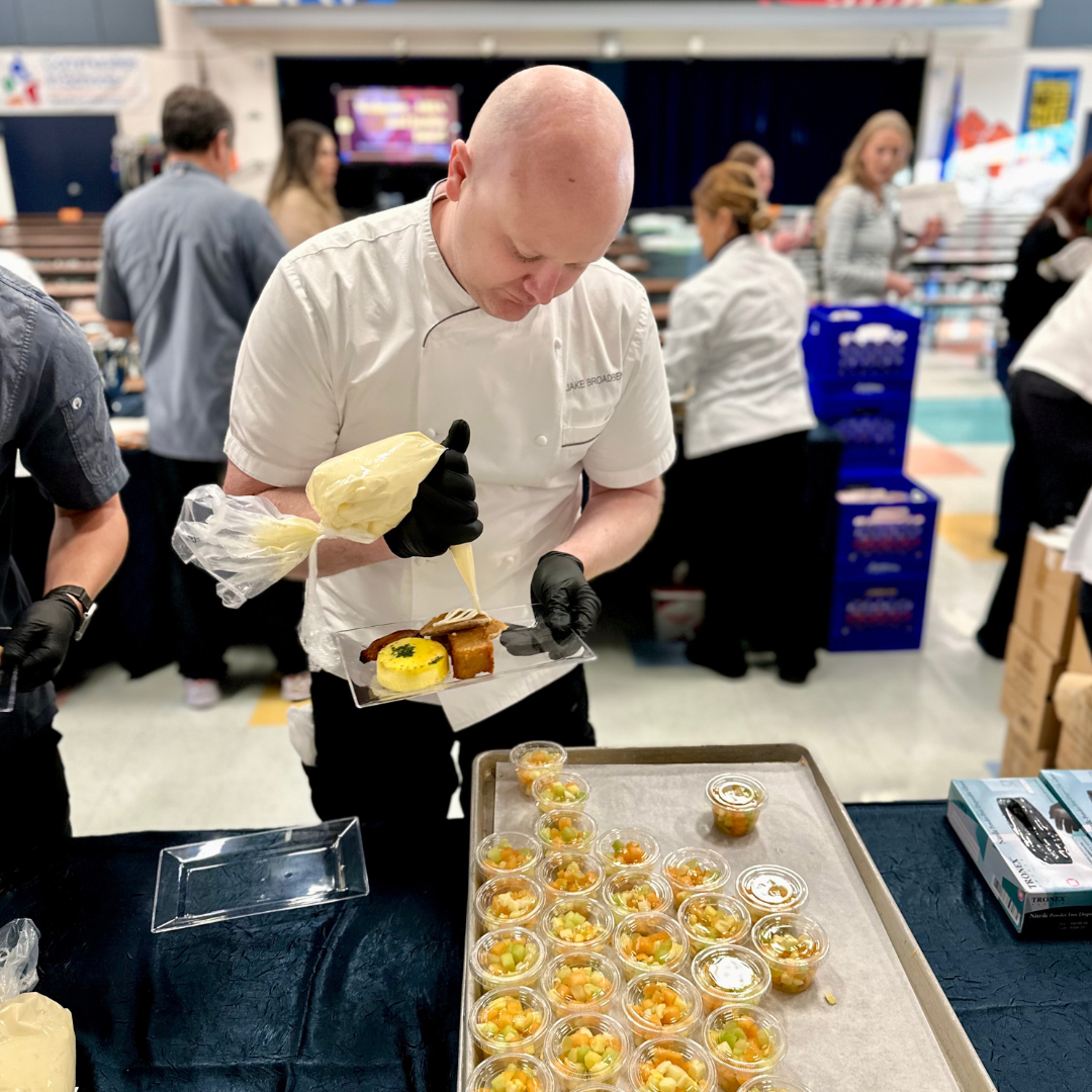 A male chef adds a topping to banana pancakes