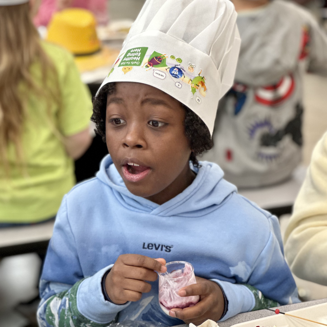 A student eats a parfait at breakfast