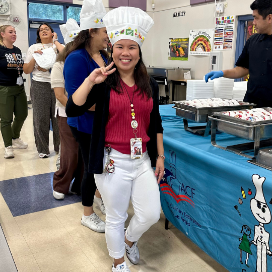A teacher flashes the peace sign while standing in line for breakfast