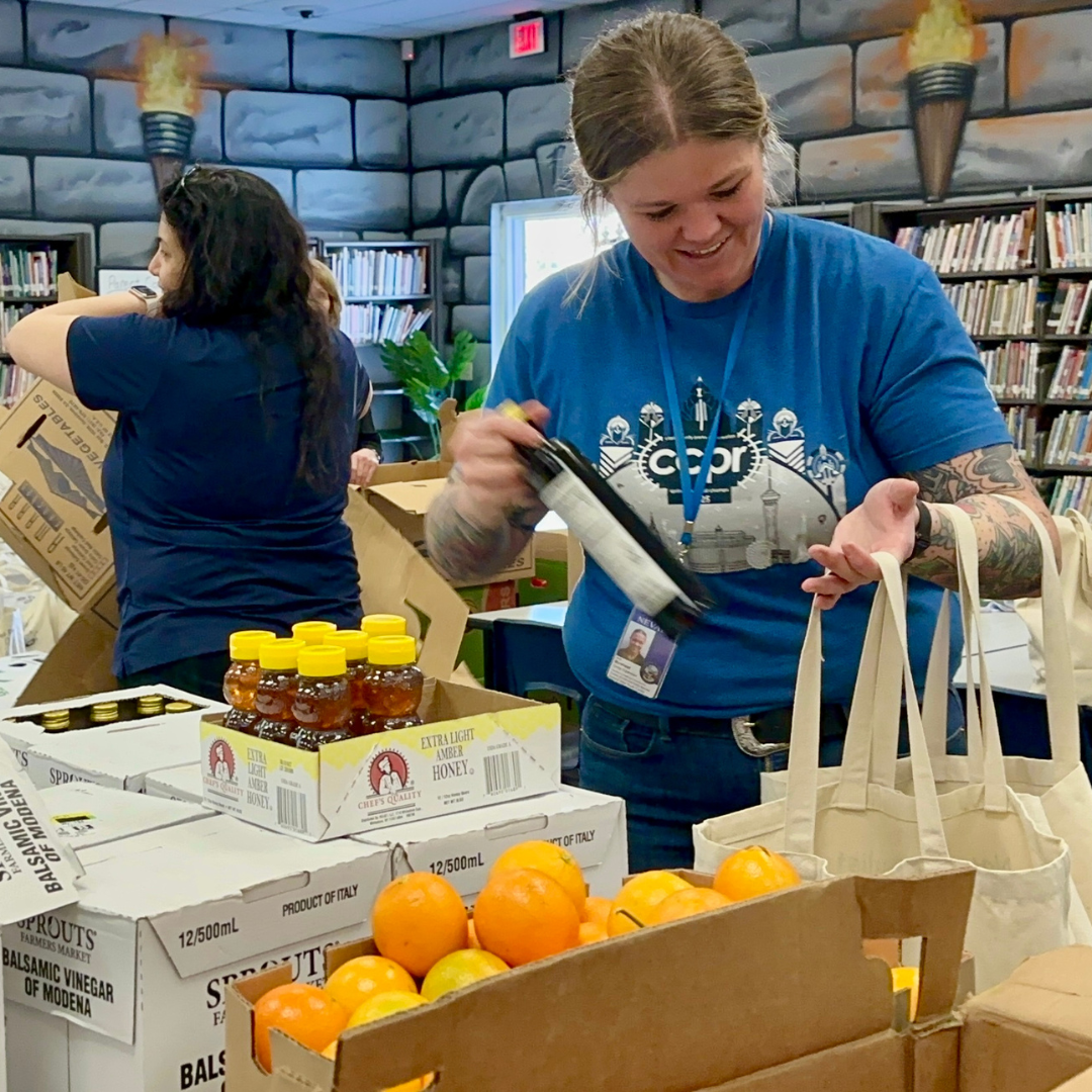 A volunteer packs a bag full of food