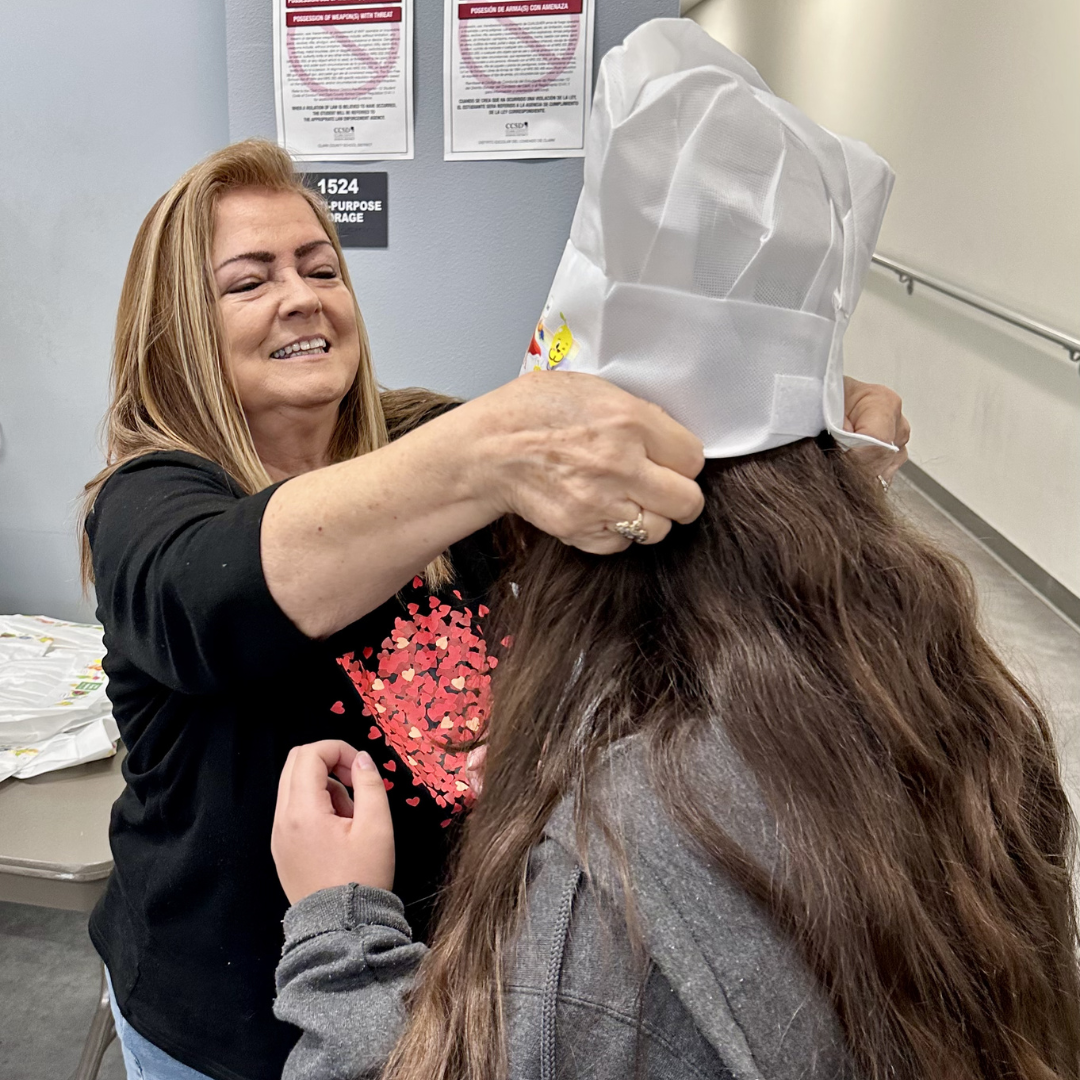 A volunteer places a hat on a child