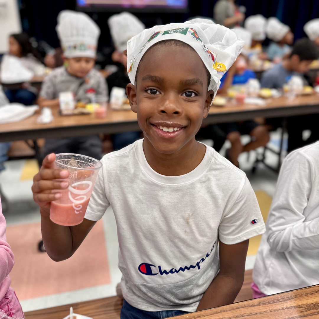 A young student smiles with a smoothie mustache