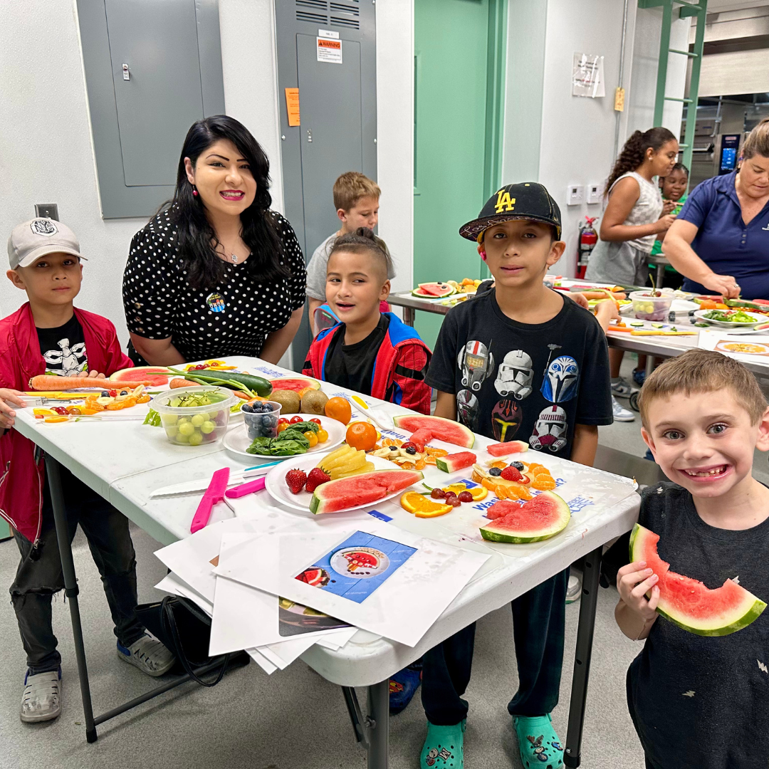 Charity Joy Mills takes a photo with kids at Produce Picasso