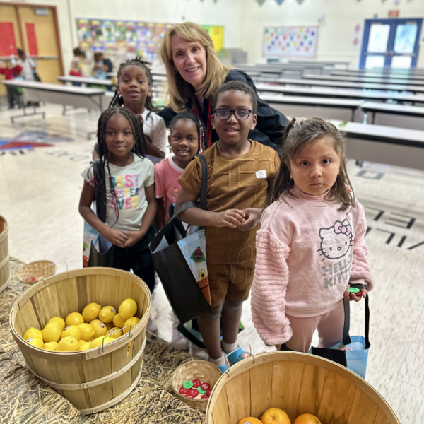 Children pose for a photo with Ms. Momii at the farmers market