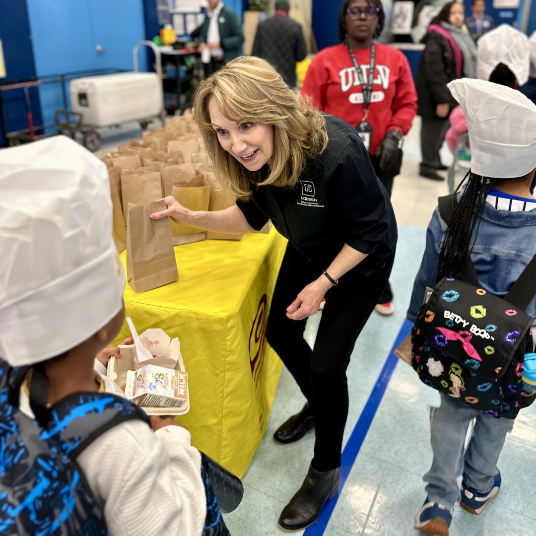 Crystal hands a bag to a child