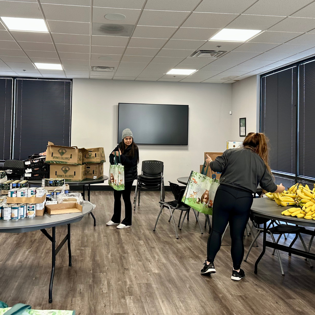 Elite Commercial Realty volunteers stuff bags with fresh produce