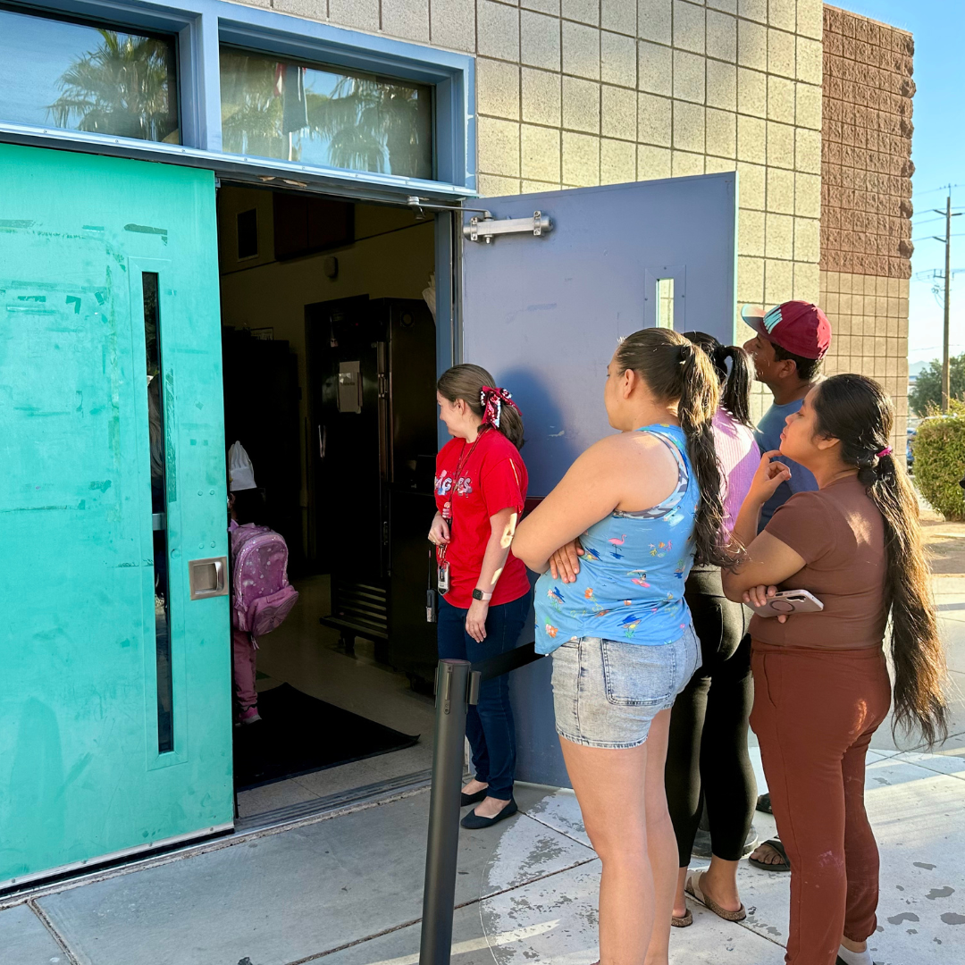 Parents look inside the cafeteria through the doorway