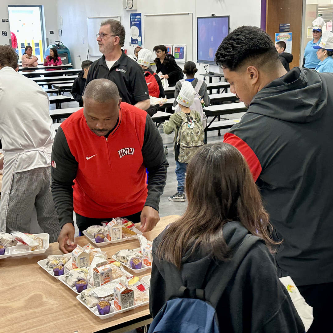 The UNLV Football coach prepares trays of food for kids