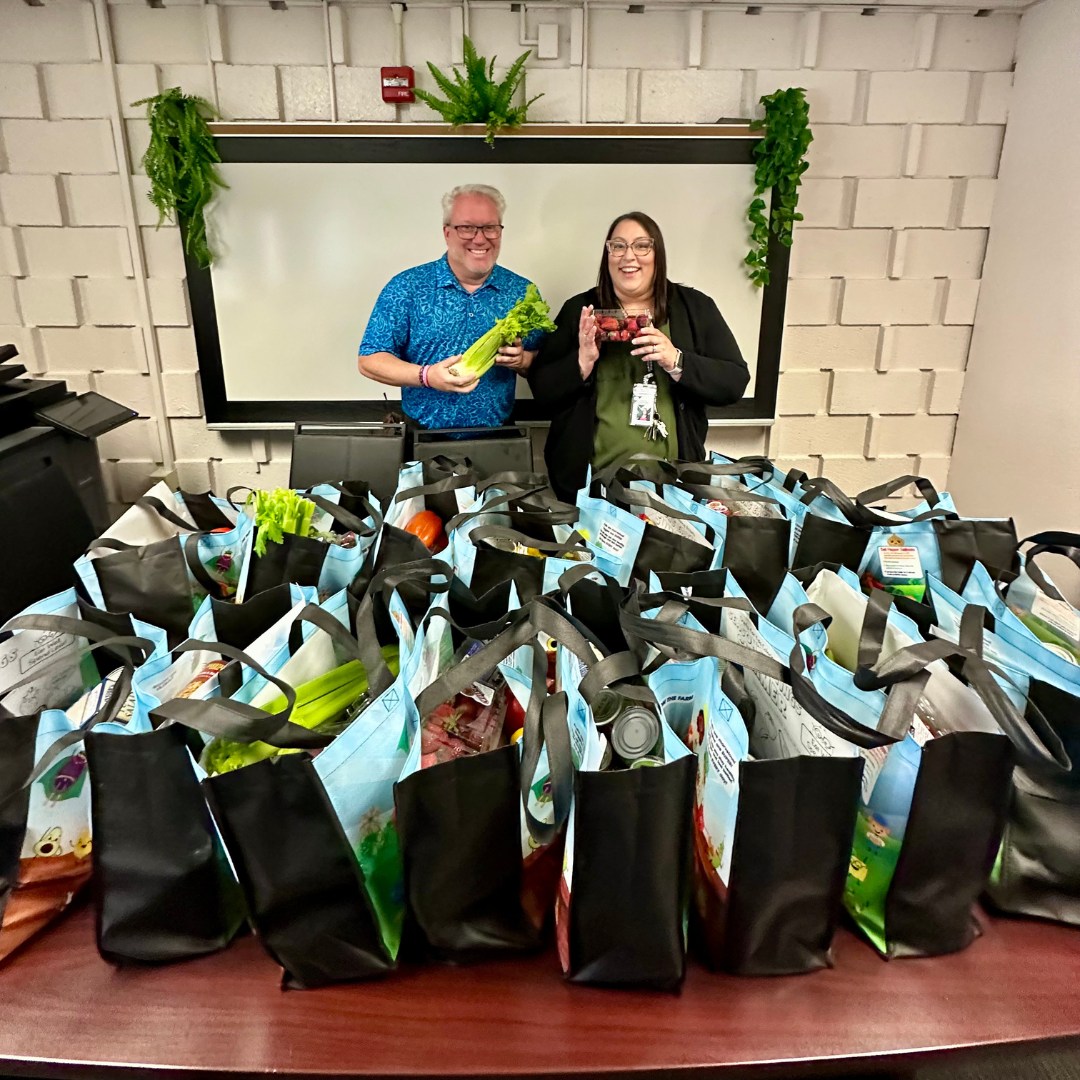 The principa and assistant principal with bags of donated food