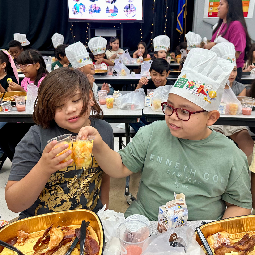 Two boys cheers toast with fruit cups