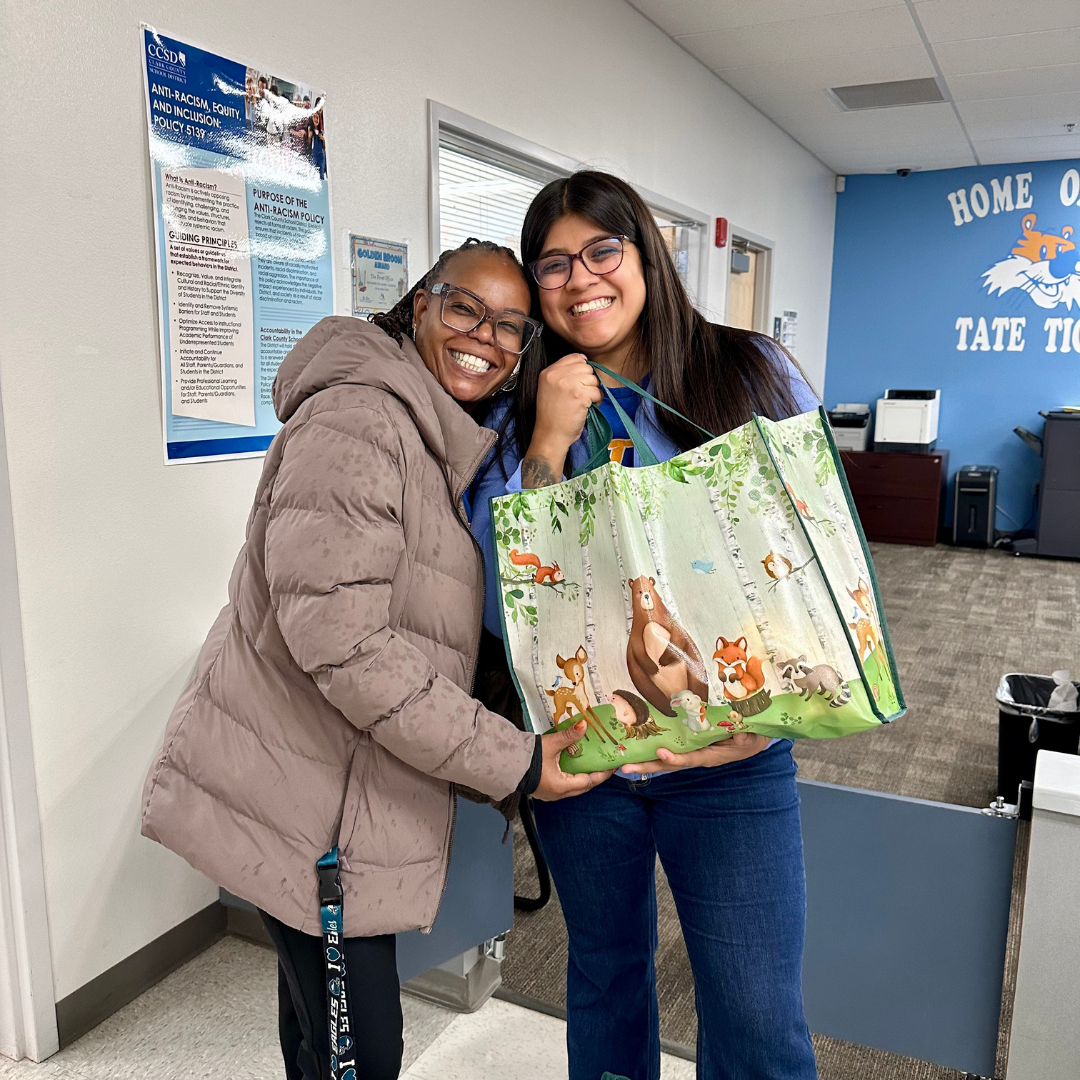 Two educators at Tate Elementary School Hold a bag of produce