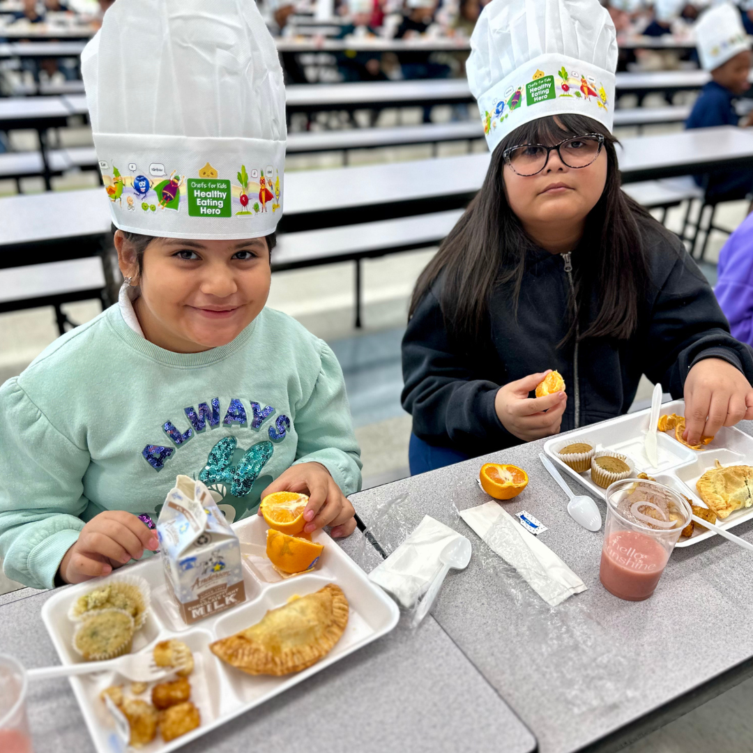 Two female students eat breakfast at Tate ES